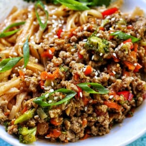 Ground Turkey Teriyaki with green onions, broccoli, carrots, and red bell peppers, in a white bowl with cilantro garnish.