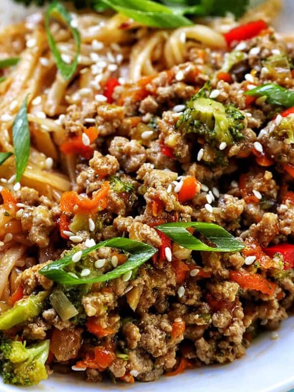 Ground Turkey Teriyaki with green onions, broccoli, carrots, and red bell peppers, in a white bowl with cilantro garnish.