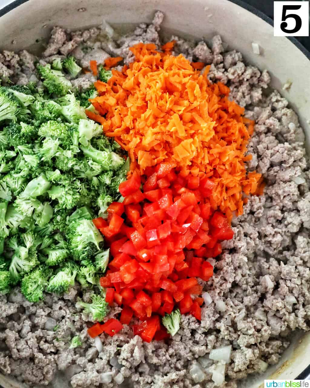 red bell peppers, carrots, and broccoli added to ground turkey cooking in a large skillet.