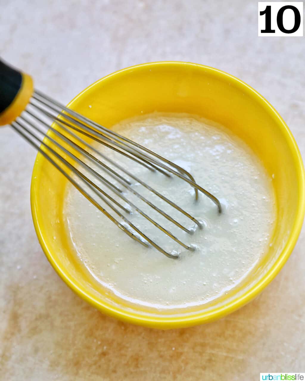 whisk in lemon glaze in a yellow bowl.