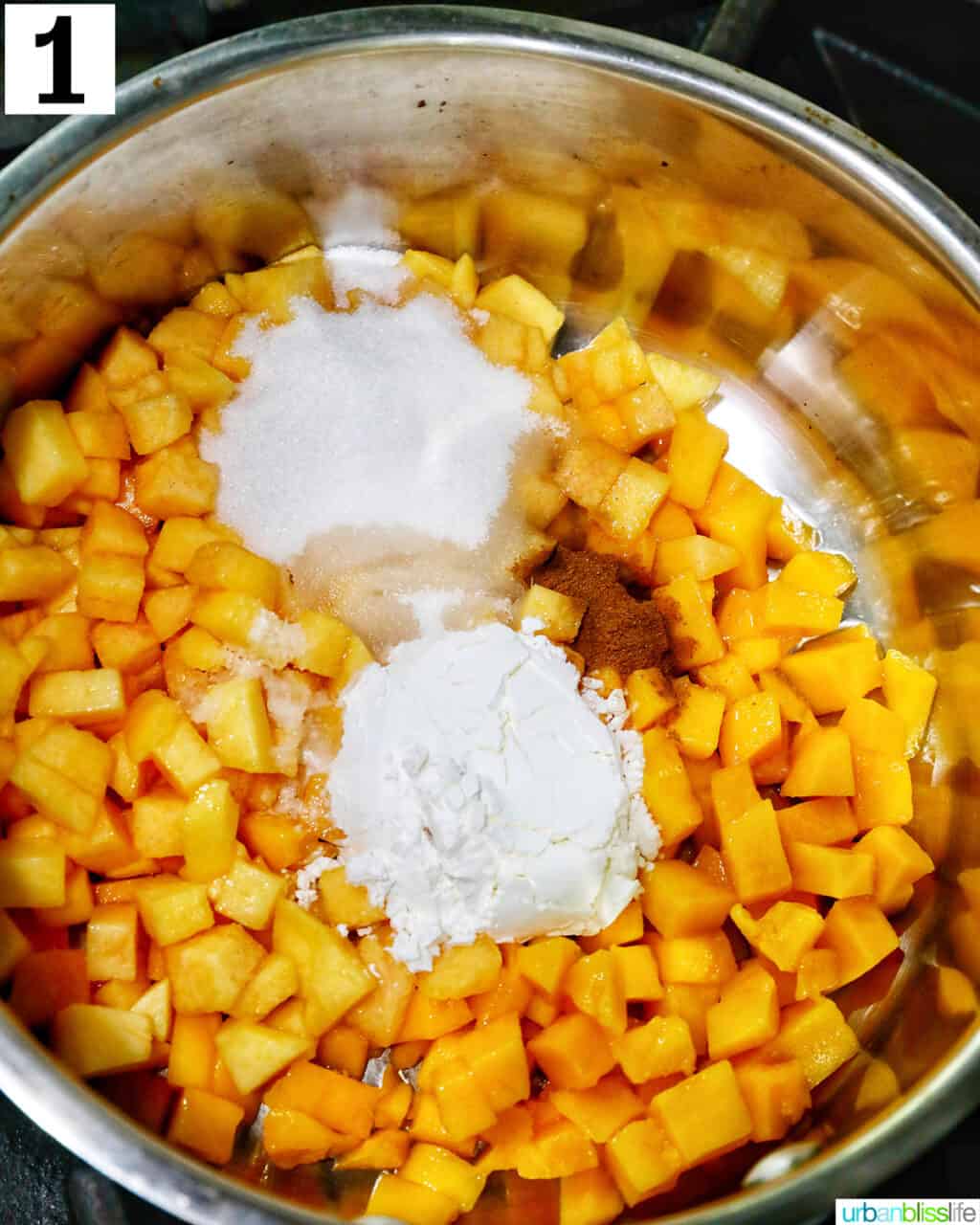 diced peaches and mangoes with cornstarch and cinnamon in a saucepan.