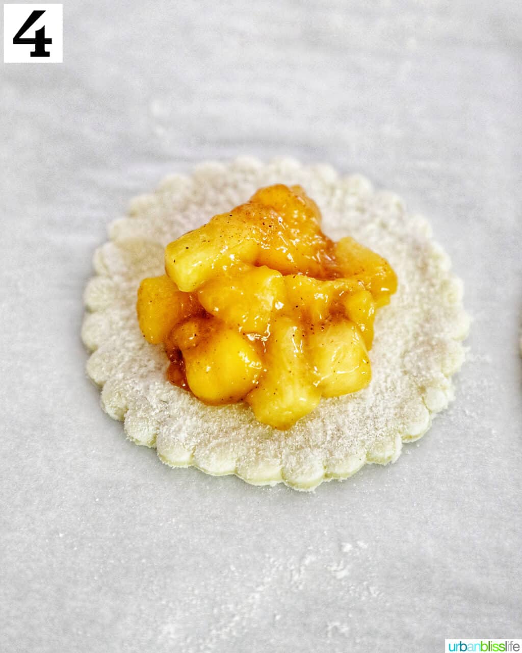 diced peaches and mango in the center of a round puff pastry dough.
