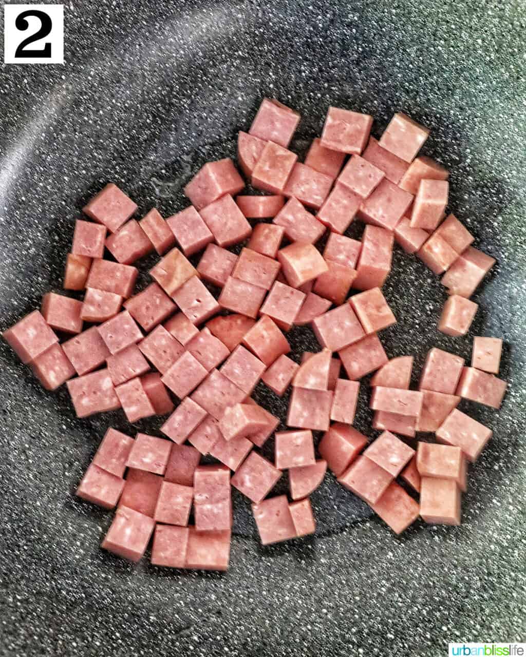 cooking cubed spam in a wok.