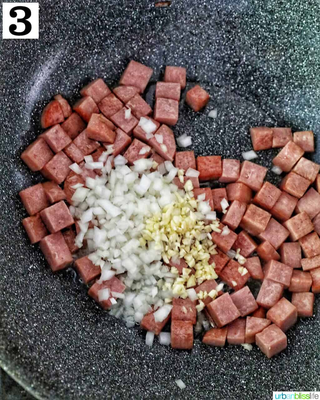 cooking cubed spam, garlic, and onions in a wok.