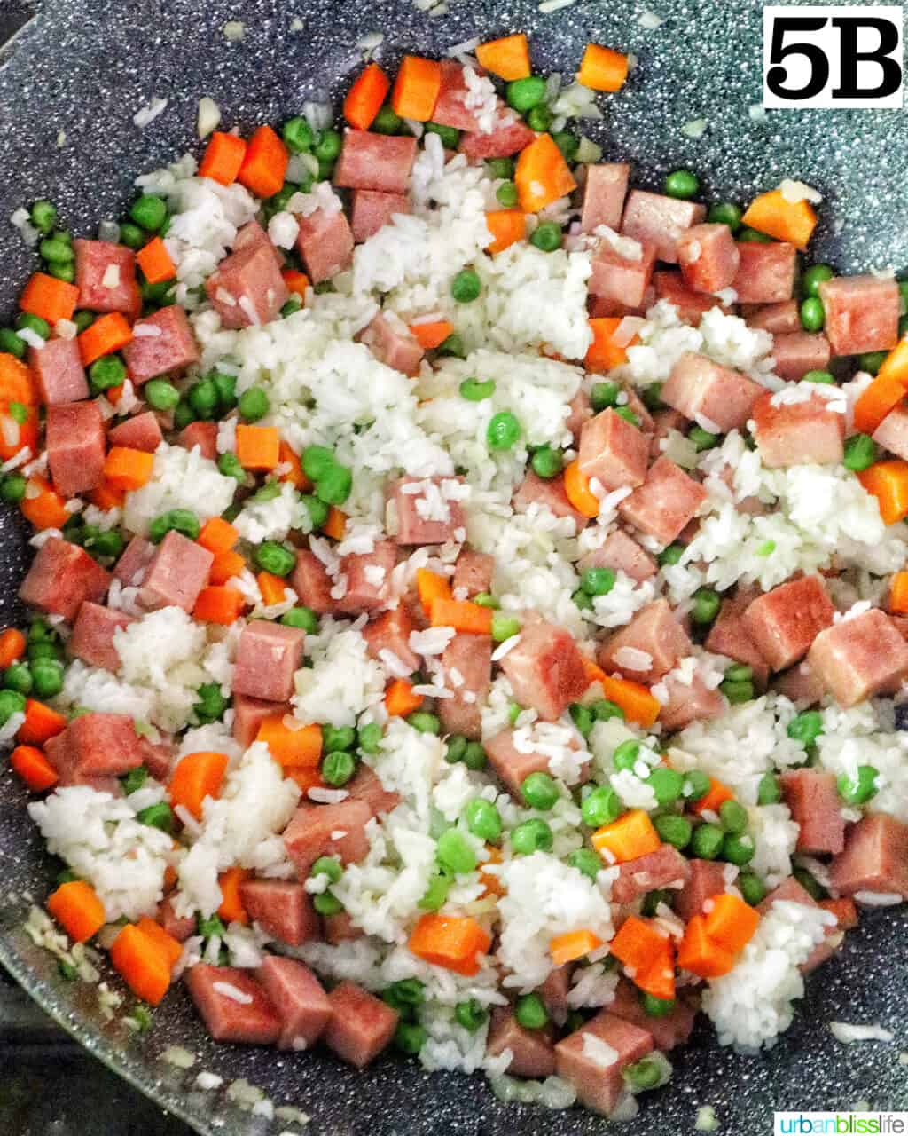 cooking spam fried rice in a wok.