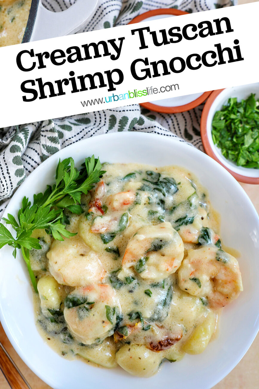 Tuscan Shrimp Gnocchi in a white bowl with garnish of parsley leaves with title text.