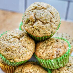 vegan zucchini muffins stacked on top of each other on a white plate.