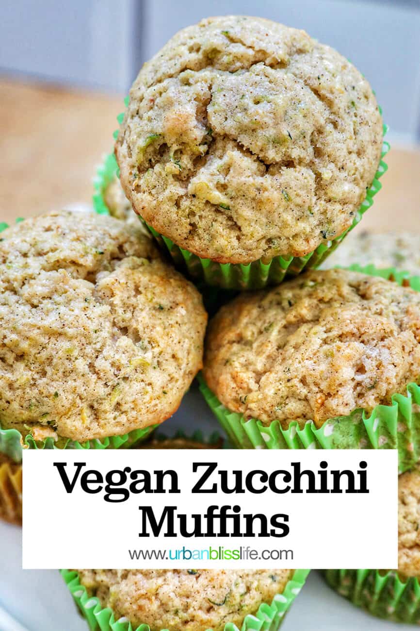 vegan zucchini muffins stacked on top of each other on a white plate with title text that reads "Vegan Zucchini Muffins."