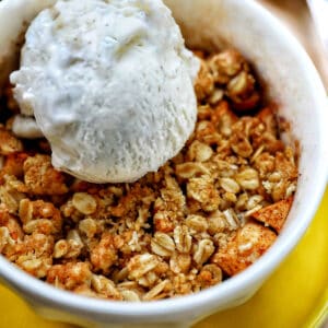 bowl of Air Fryer Apple Crisp with scoop of ice cream.