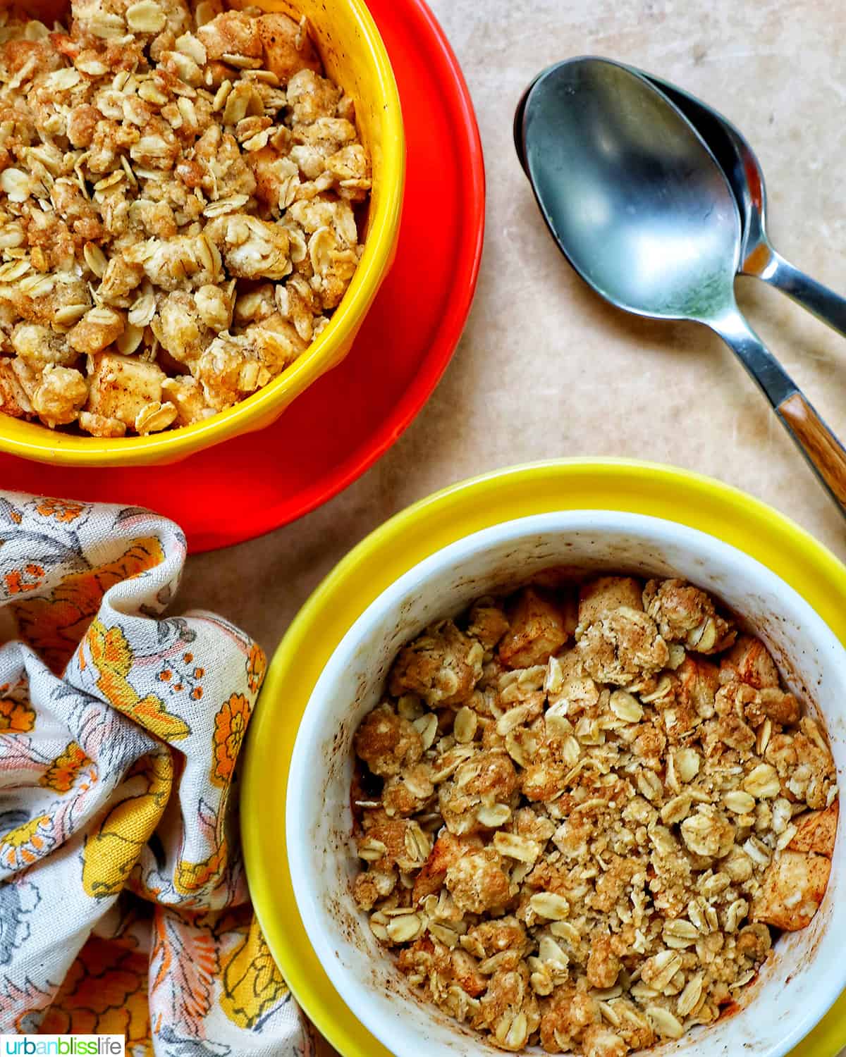 two bowls of Air Fryer Apple Crisp and spoons.