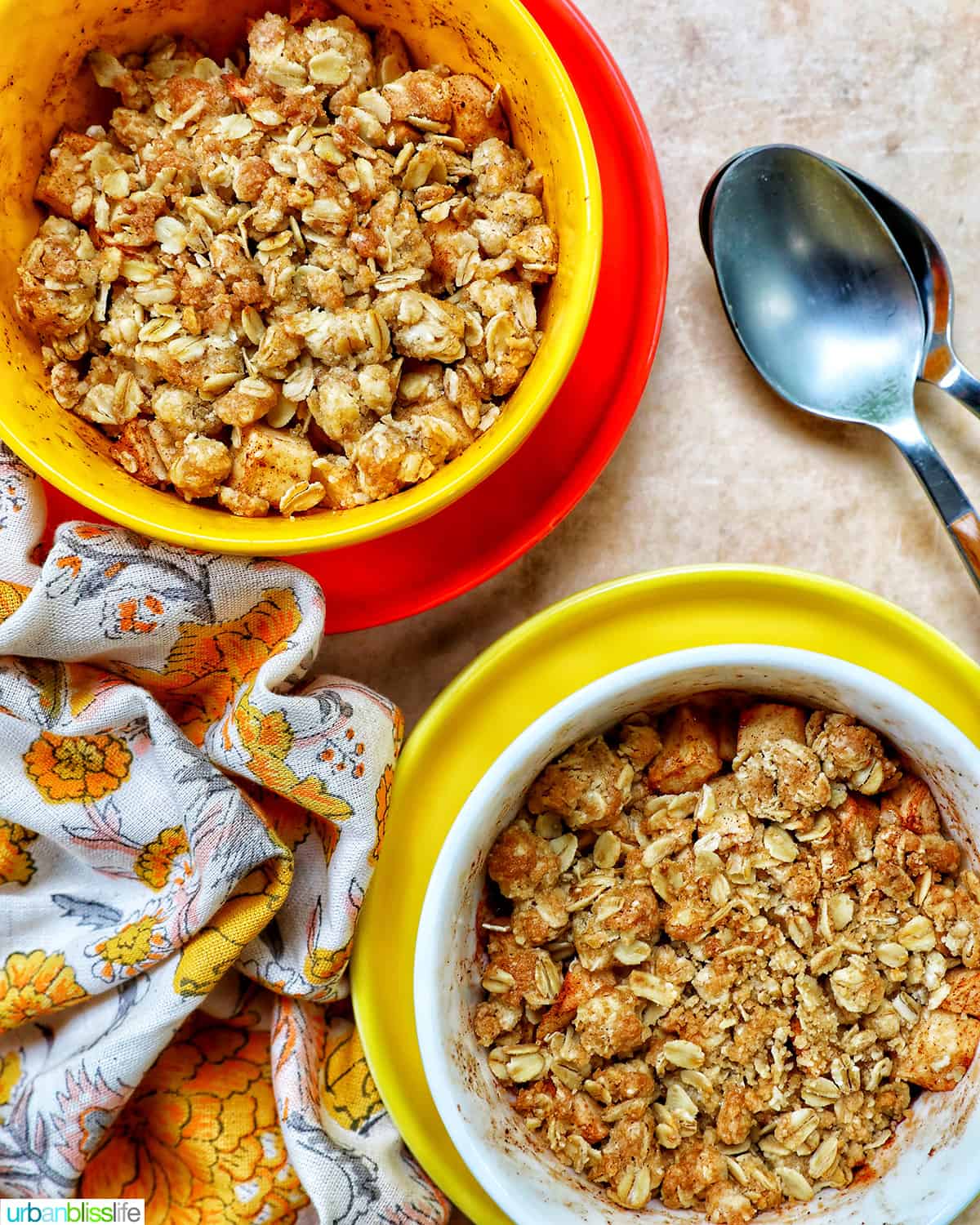 two bowls of Air Fryer Apple Crisp and spoons.