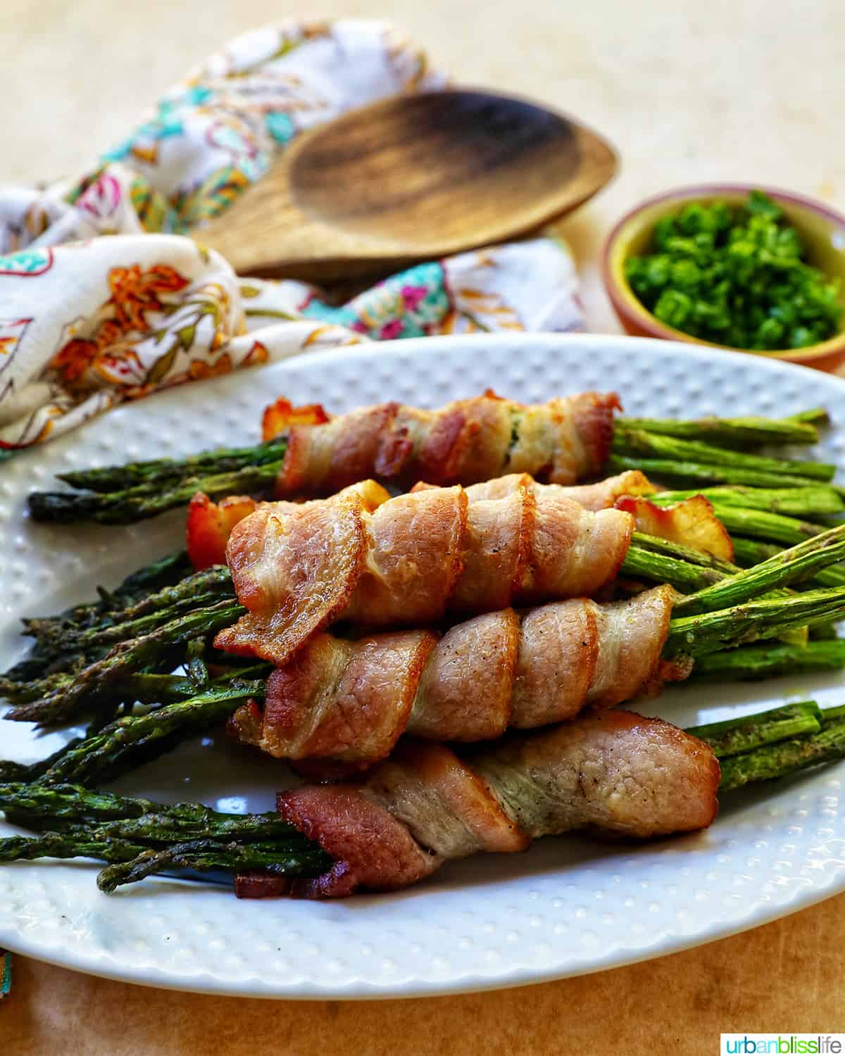 bacon wrapped asparagus on a white plate.