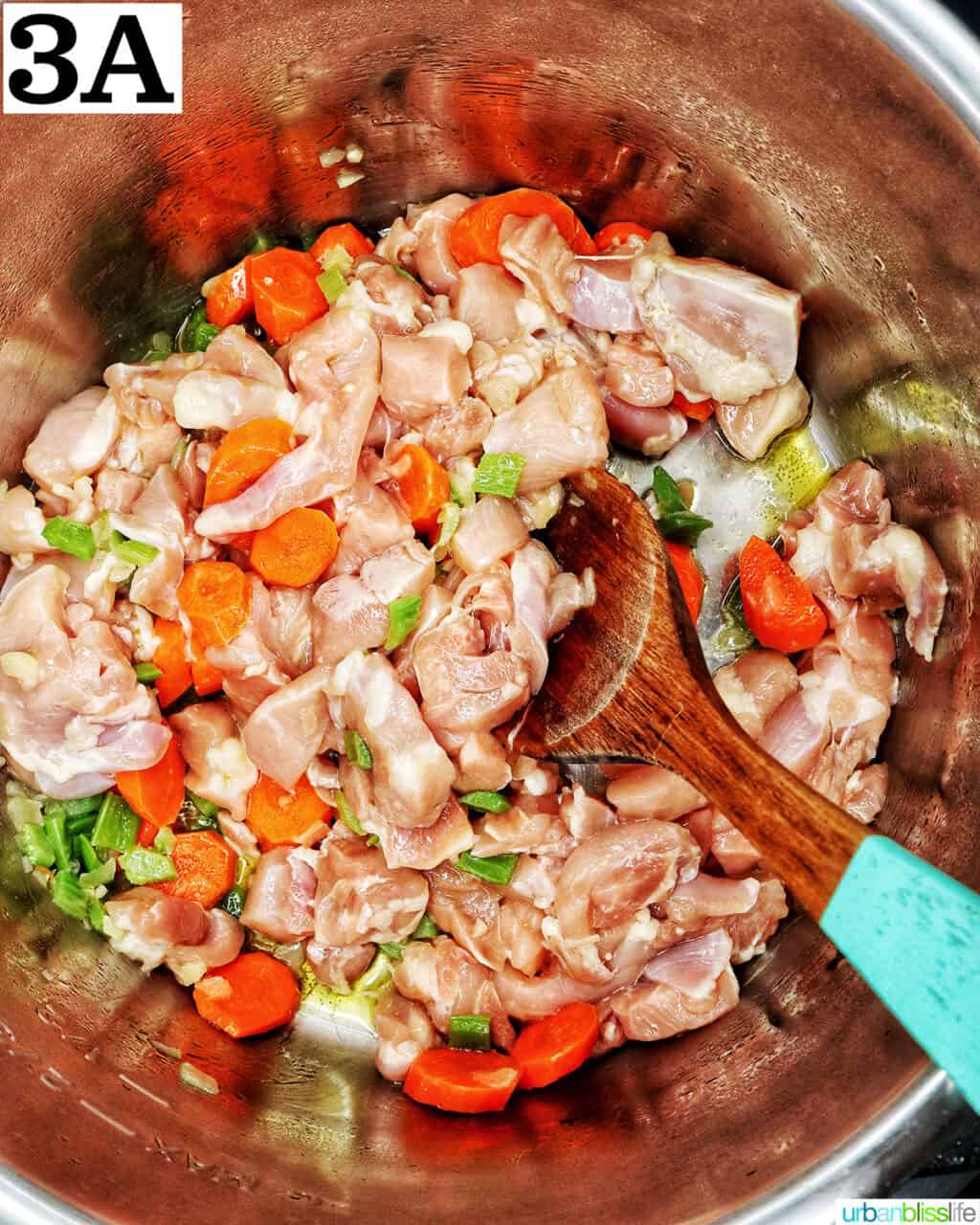 wooden spoon mixing raw chicken thigh meat with vegetables in an instant pot.
