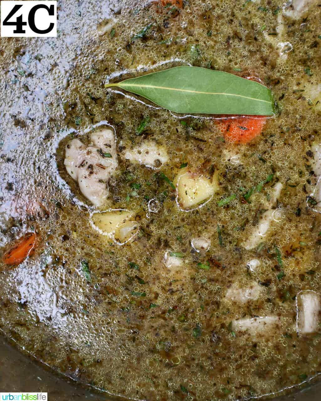 bay leaf sitting on top of chicken broth, chicken, and vegetables in an instant pot.