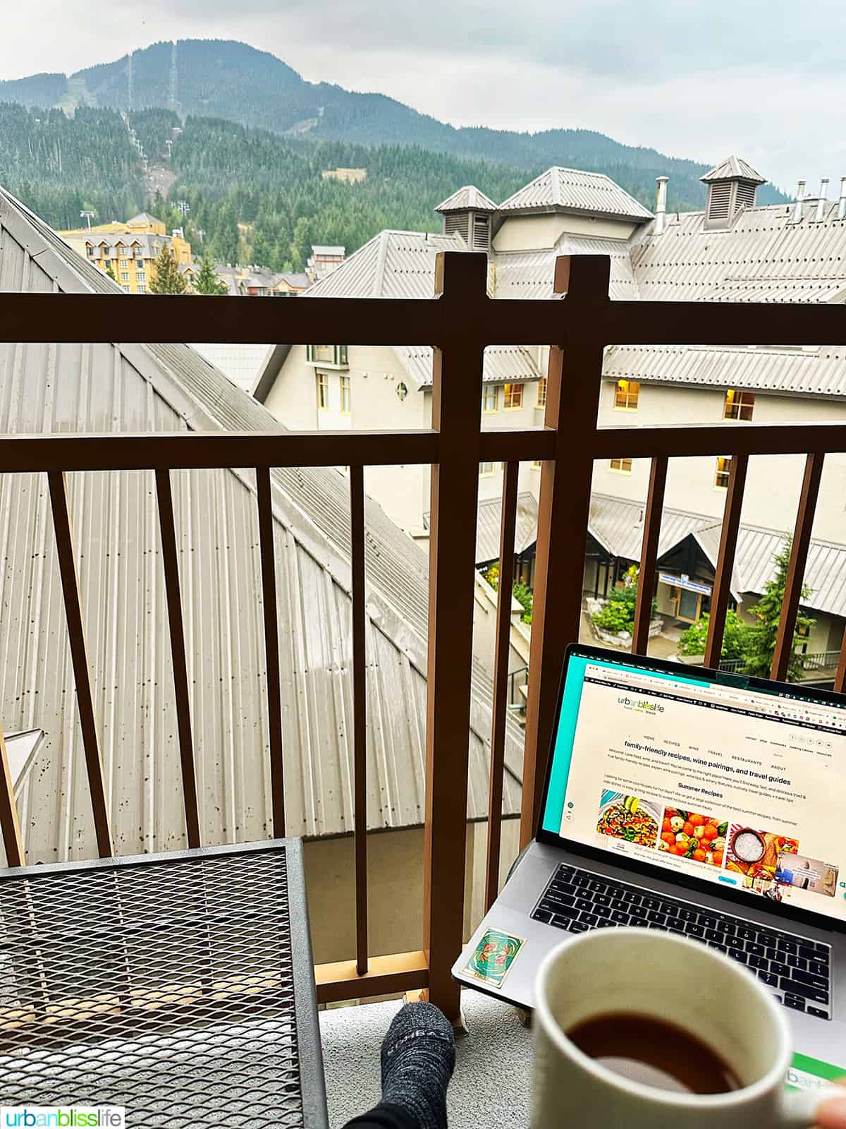 computer and coffee on the balcony of a suite at Pan Pacific Whistler Village hotel.
