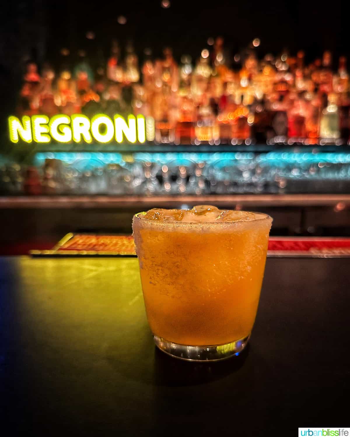 cocktail at the bar with colorful bottles in the background at the Raven Room in Whistler BC Canada.