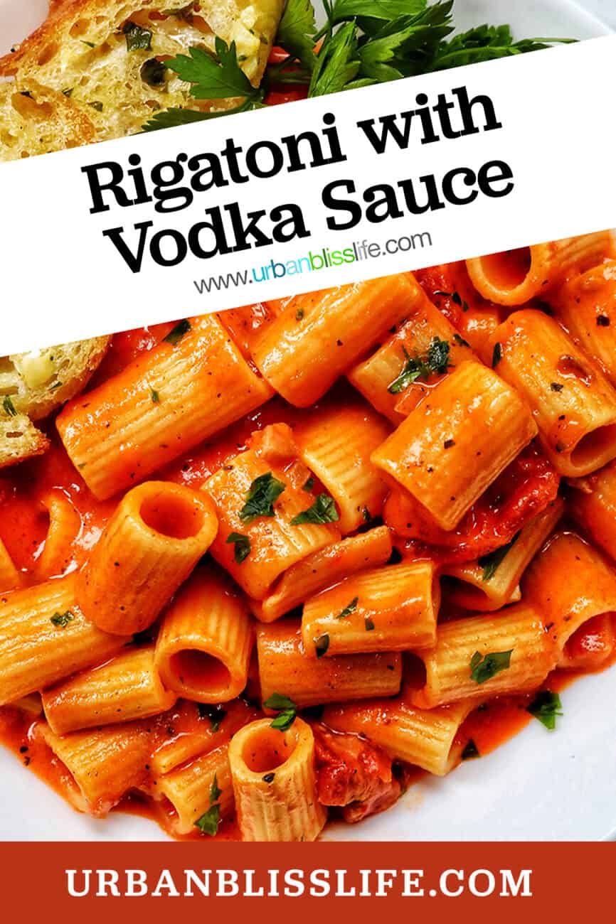 white bowl with rigatoni with vodka sauce and side of garlic bread and parsley with title text.