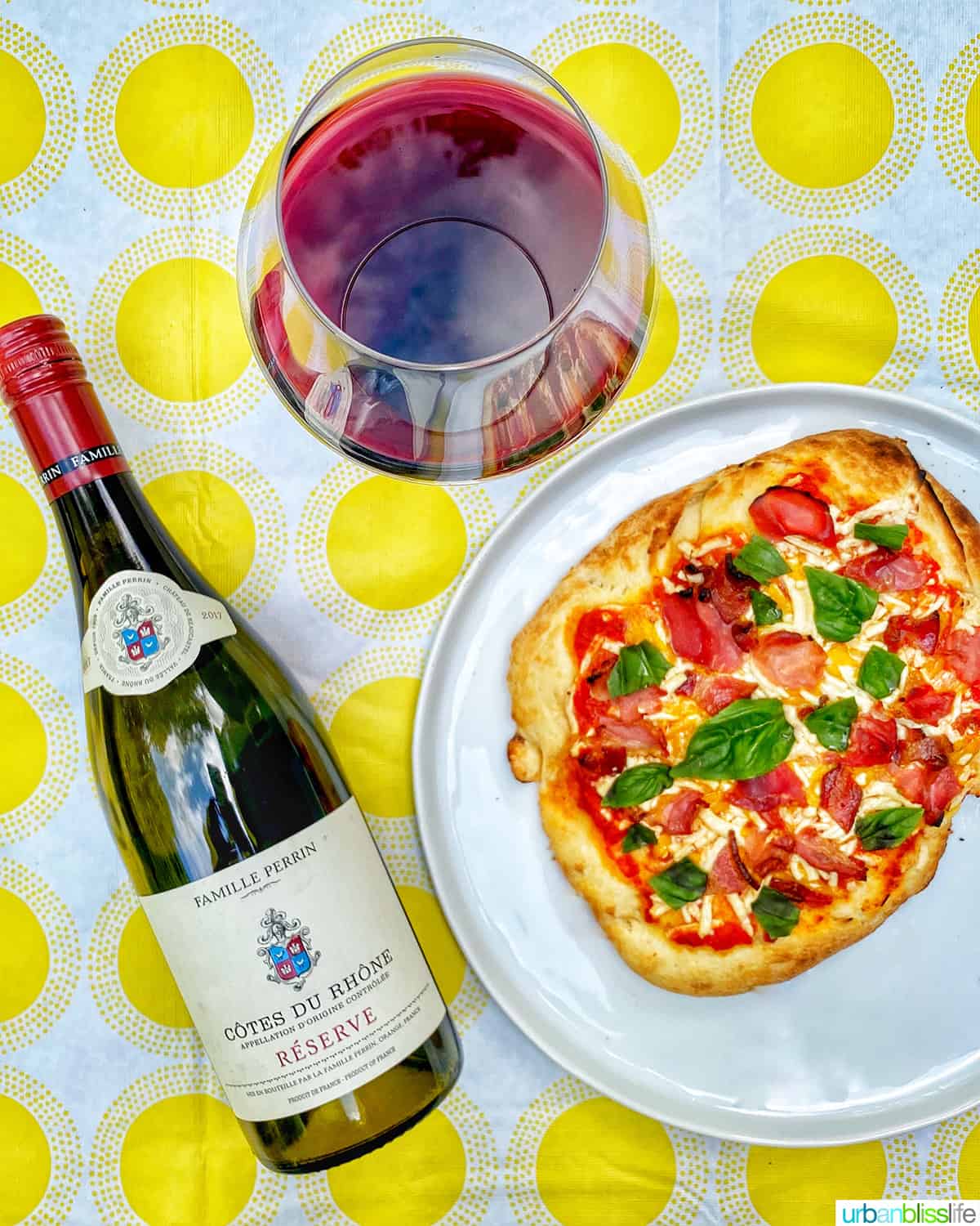 bottle of wine with glass of red wine with pizza