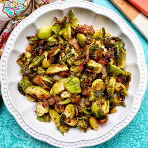 bowl of brussels sprouts with bacon with set of wooden serving spoons.