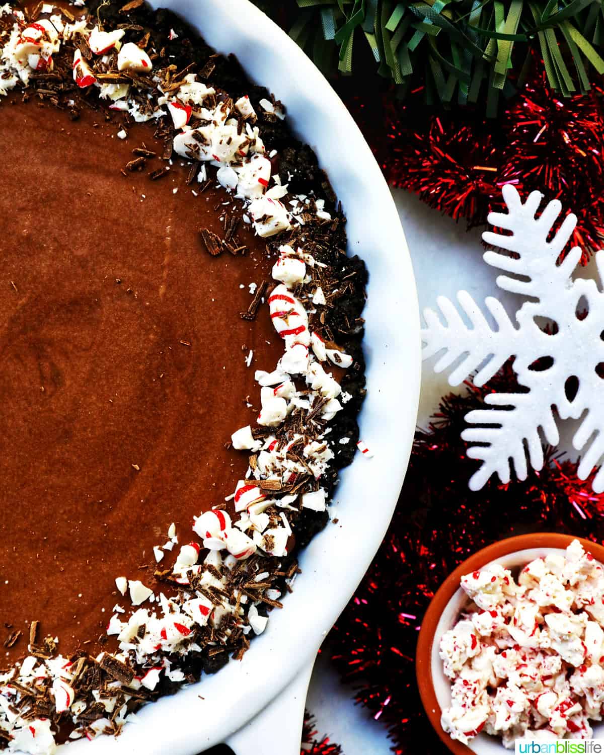 chocolate peppermint pie in a pie plate with side of crushed peppermint candies.
