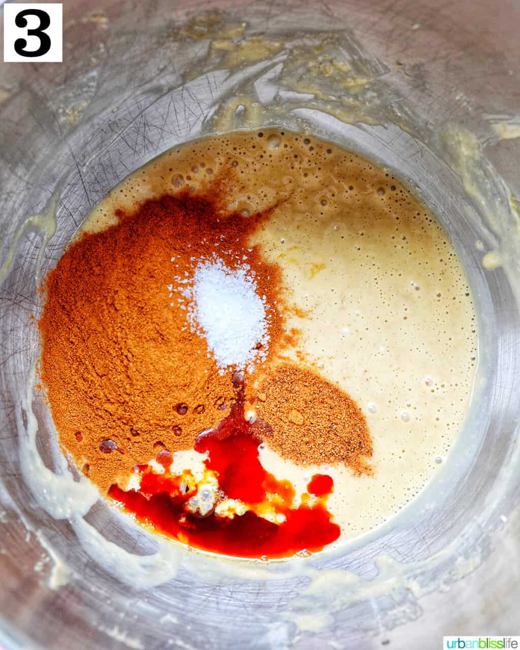 spices added to cinnamon pie batter in a stainless steel bowl.