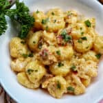 lobster gnocchi with herbs in a white bowl.