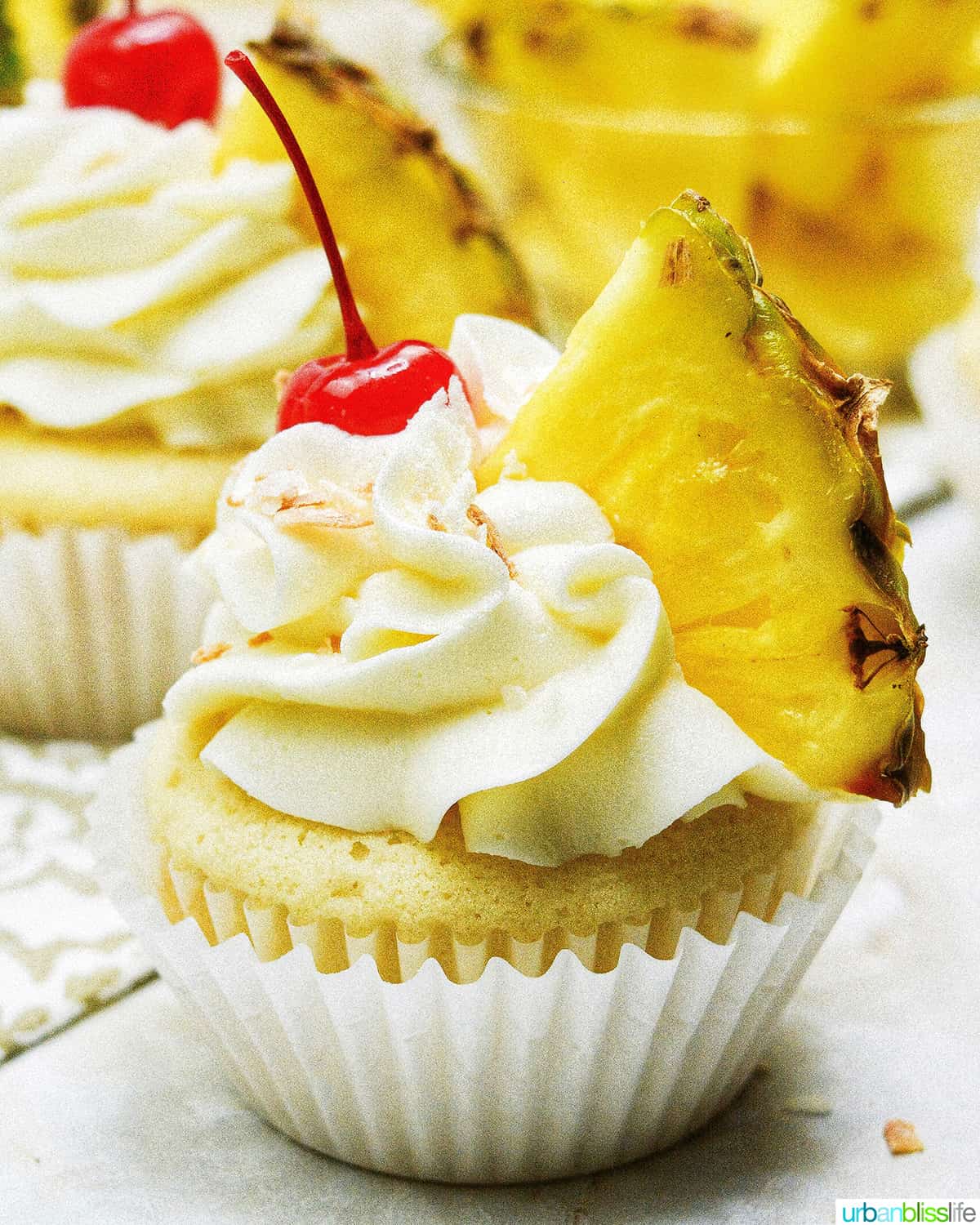 single pina colada cupcake with slice of pineapple.