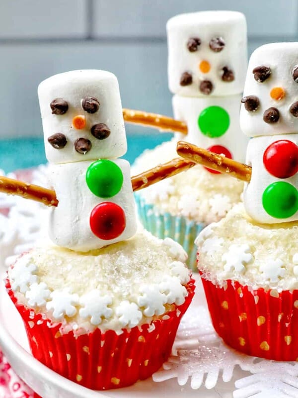 snowman cupcakes with marshmallows, pretzels, and sprinkles.