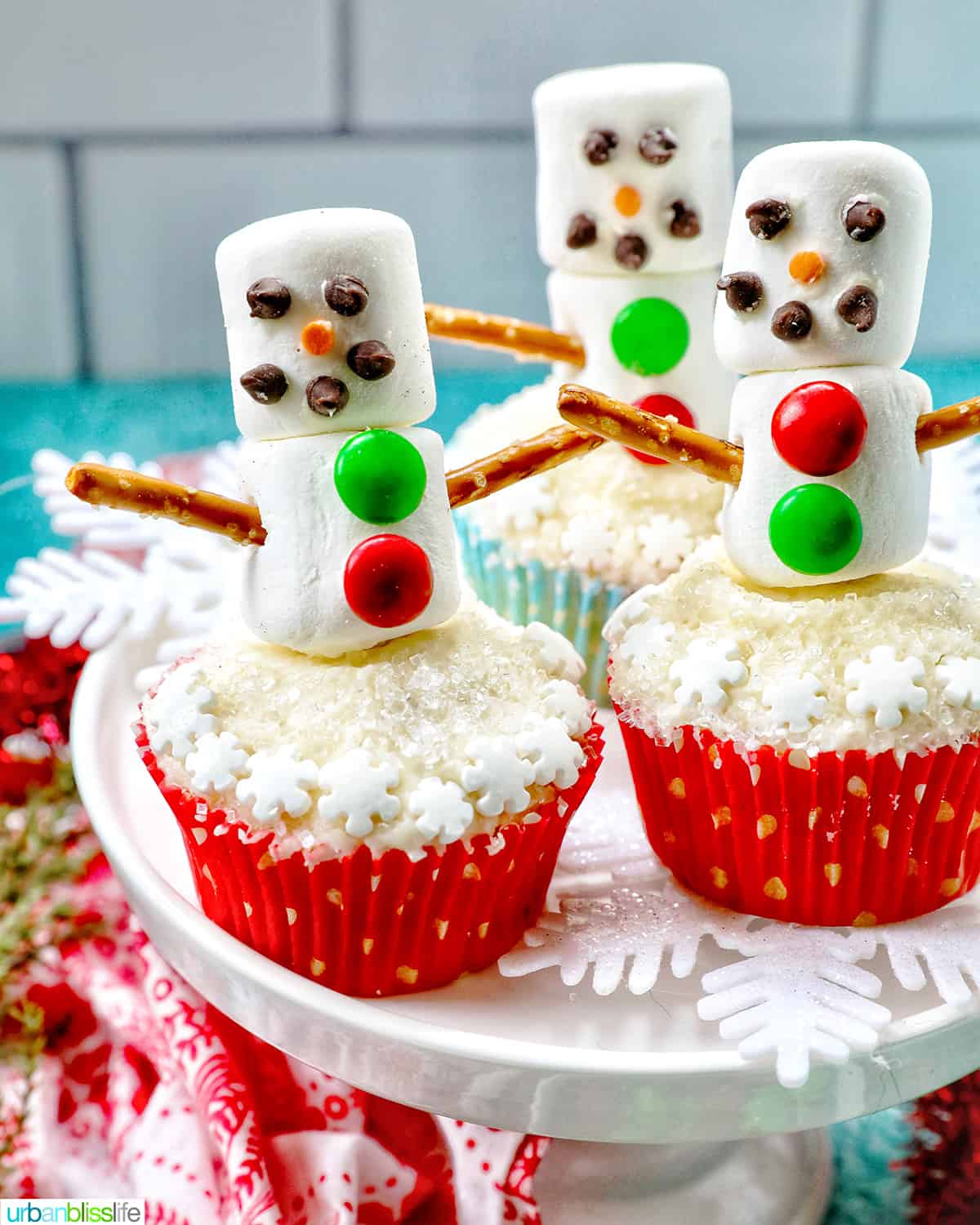 snowman cupcakes with marshmallows, pretzels, and sprinkles.