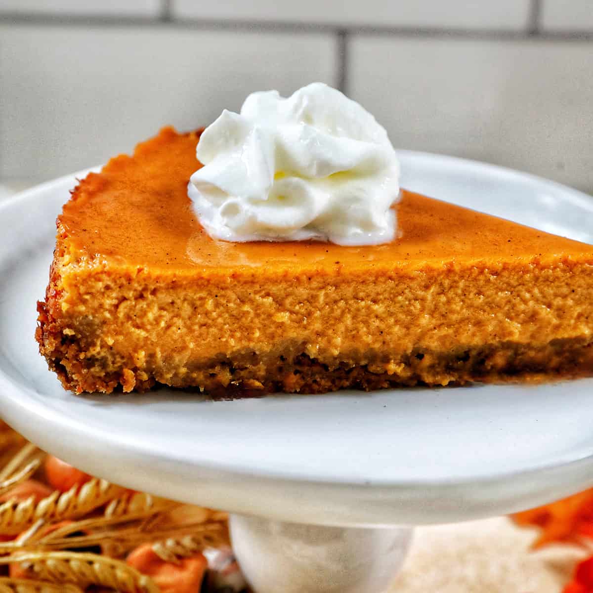 slice of sweet potato pie with whipped cream on a white plate.