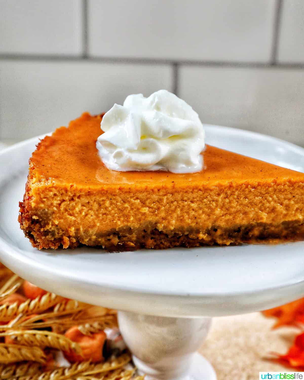 slice of sweet potato pie with whipped cream on a white plate.