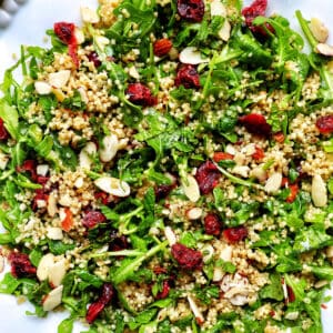 arugula and quinoa salad with sliced almonds and dried cranberries.