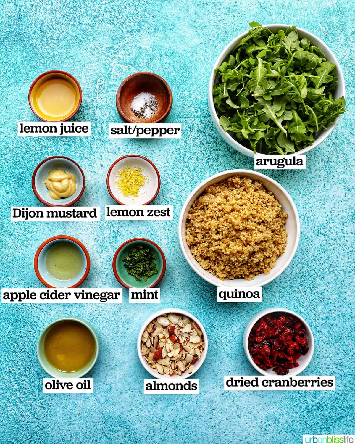 bowls of ingredients to make arugula and quinoa salad.