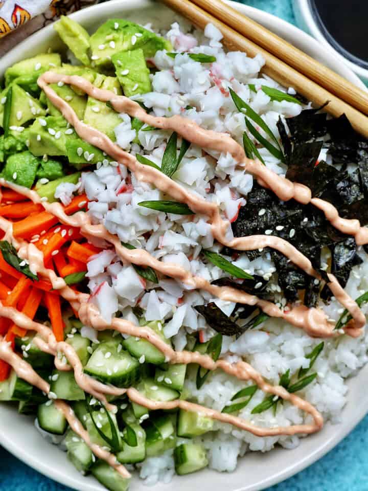 Carlifornia Sushi Bowls with crab, cucumbers, carrots, avocado, nori over white rice and drizzled with a sriracha mayo.