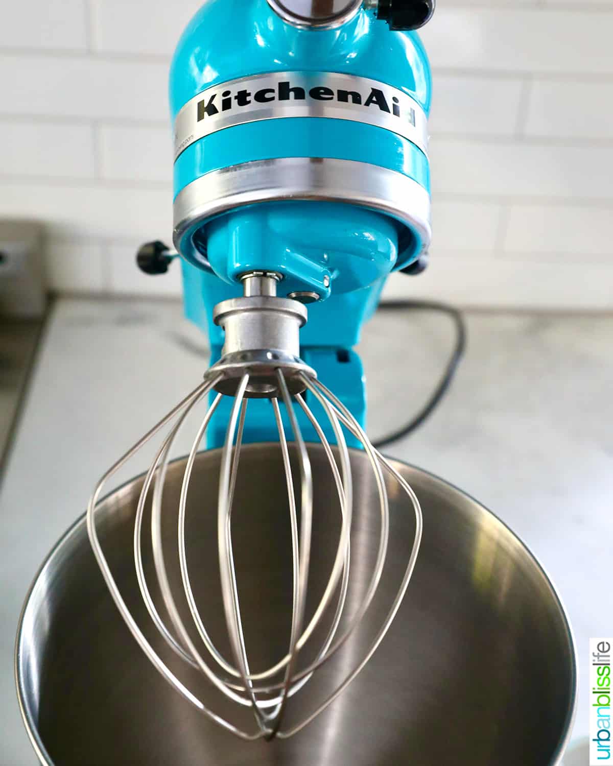 aqua blue Kitchenaid stand mixer with whisk attachment.