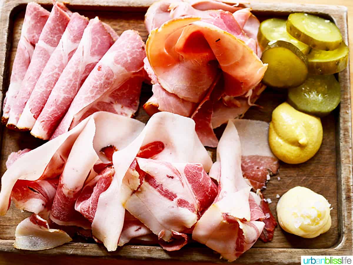 charcuterie board with ham, pickles.