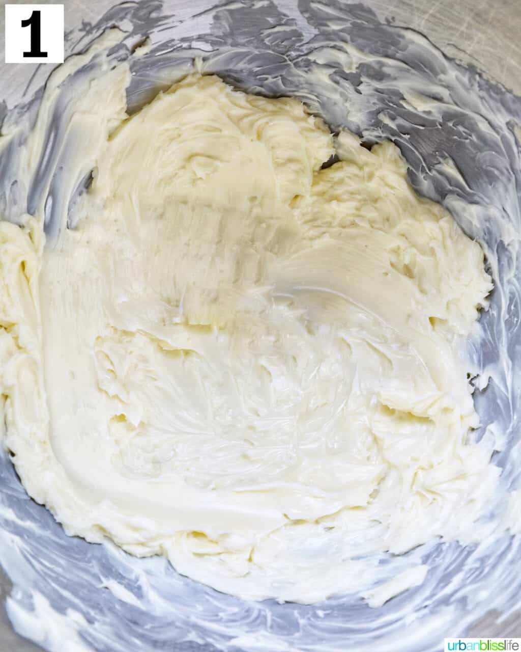 Creaming butter in the stainless steel bowl of a stand mixer.