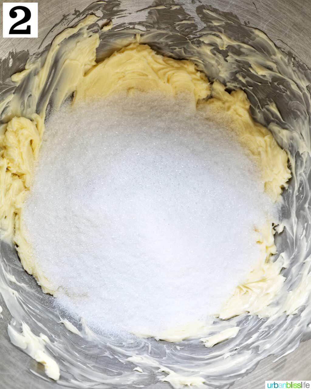 Creaming sugar and butter in the stainless steel bowl of a stand mixer.