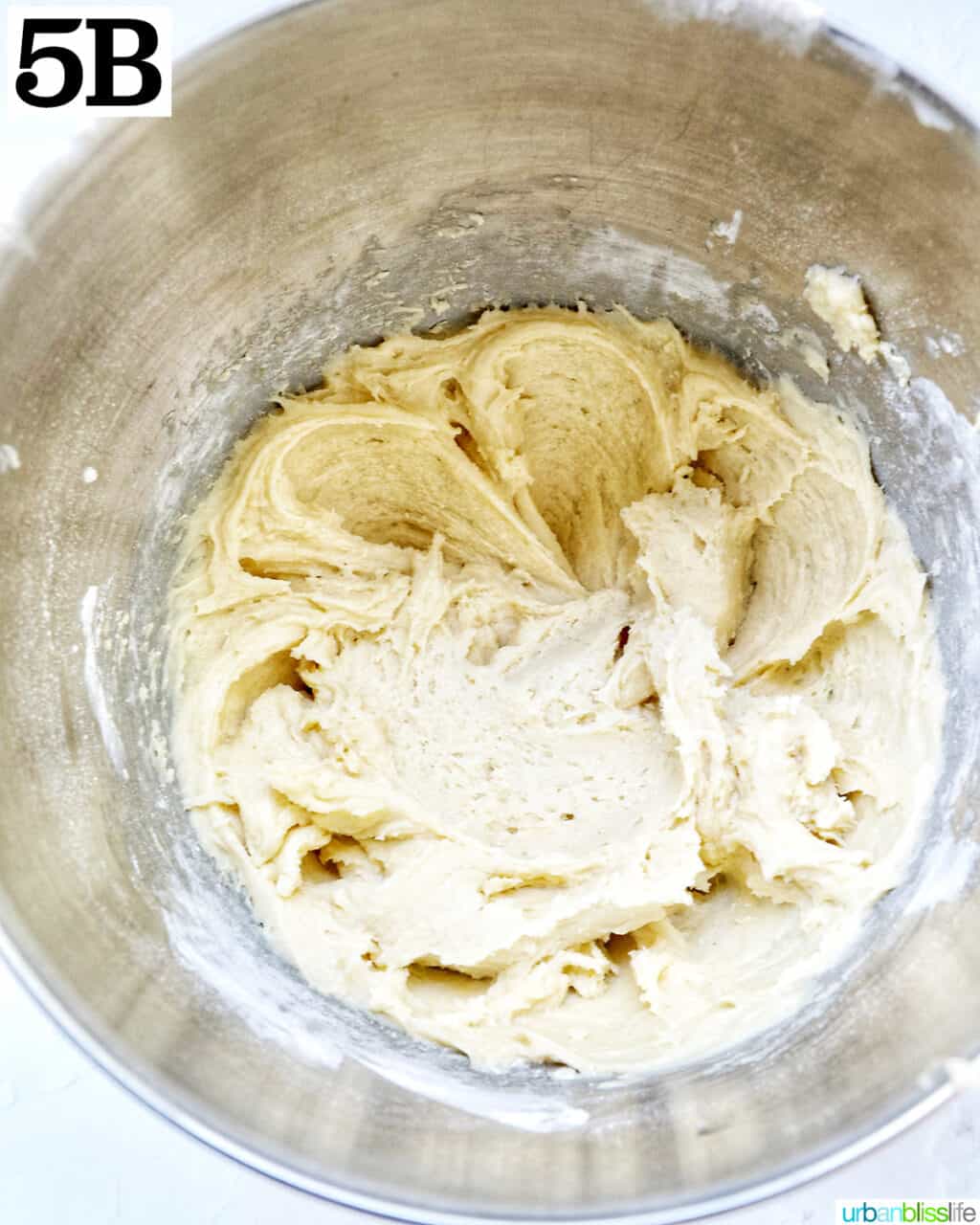 Creamed cake batter in the stainless steel bowl of a stand mixer.