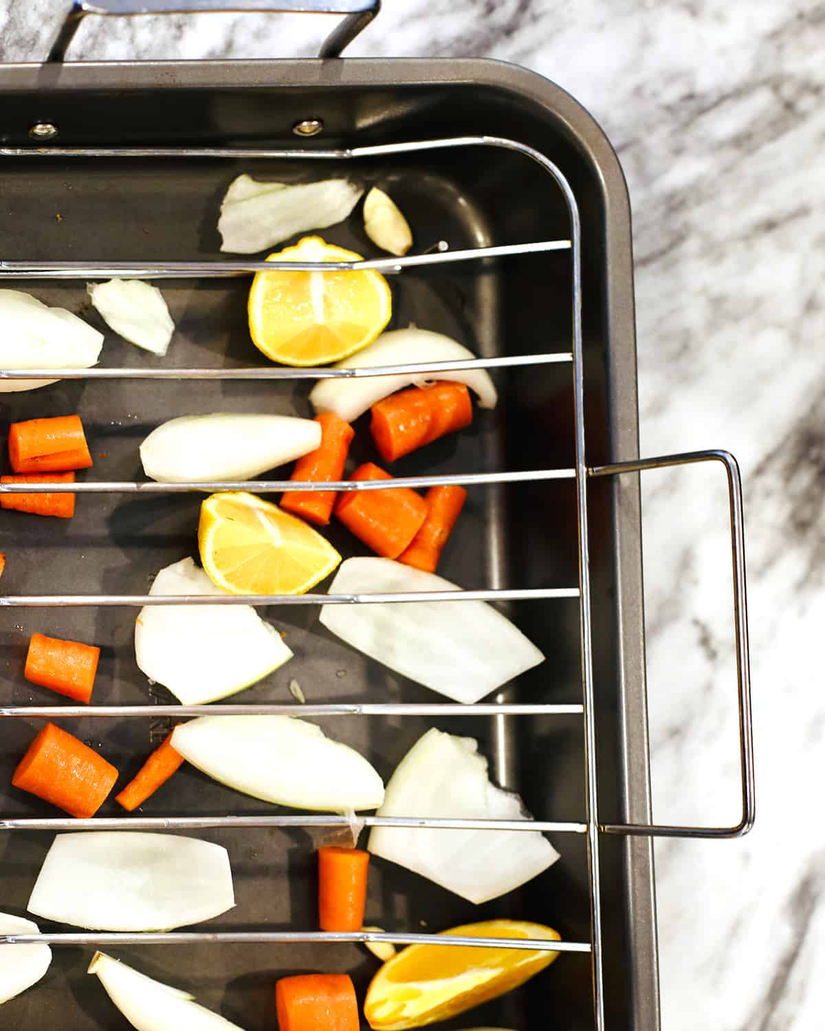 chopped vegetables in a roasting pan with roasting rack.