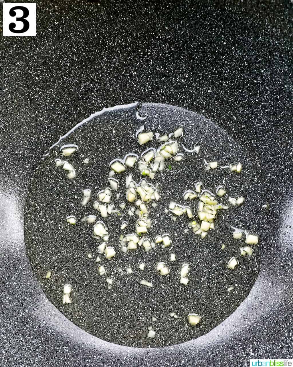 minced garlic cooking in oil in a wok.