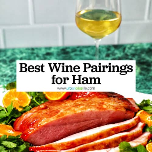 glass of white wine behind honey glazed ham sliced with oranges and herbs, and title text overlay.