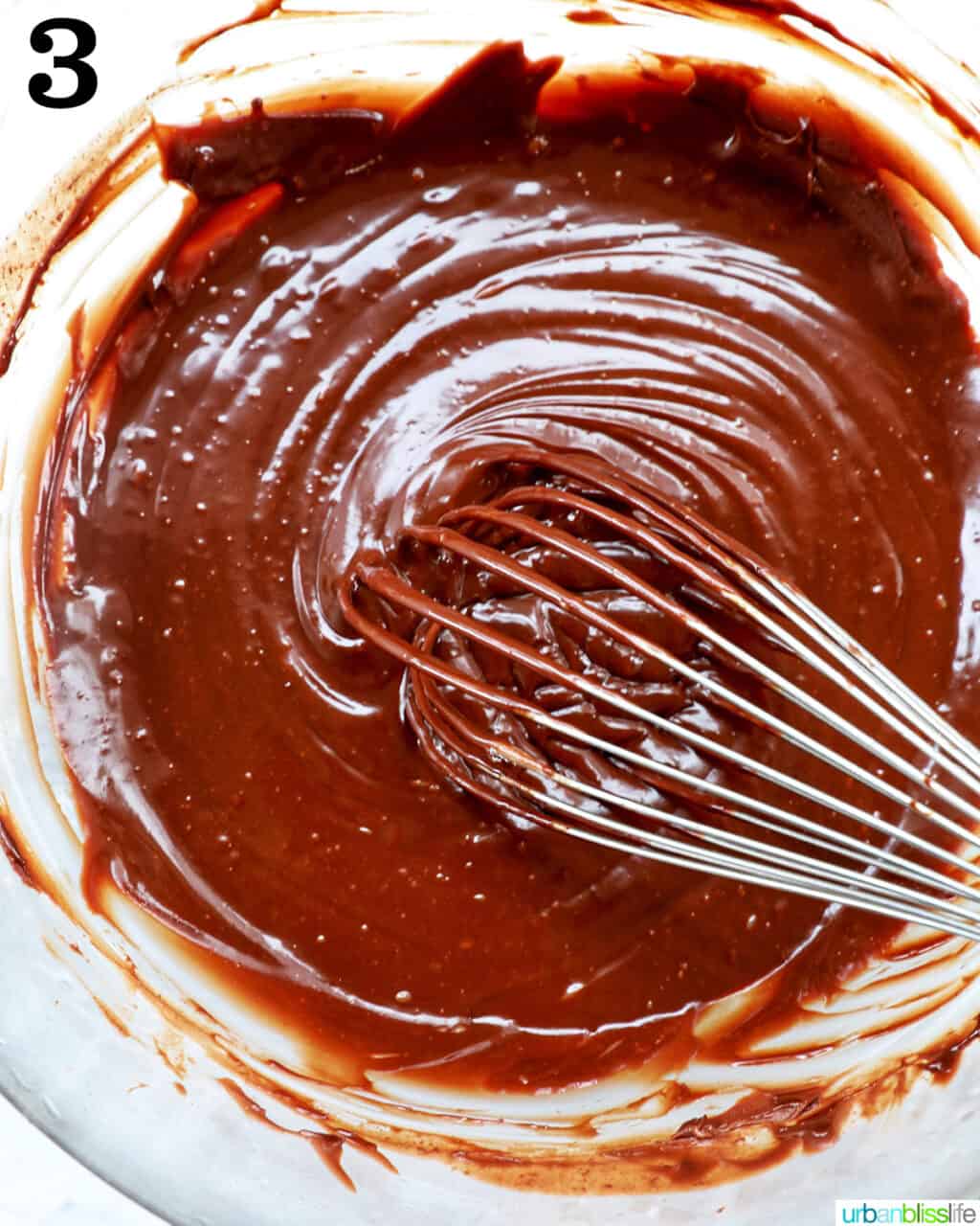 whisk with chocolate ganache in a bowl.