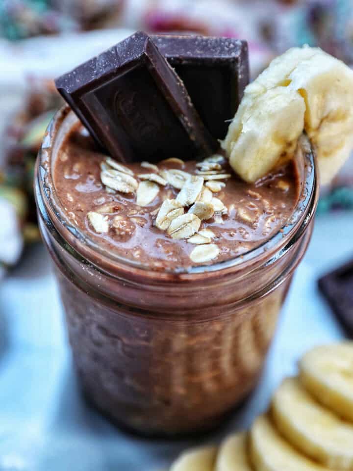 chocolate protein overnight oats topped with banana slices and chocolate pieces.