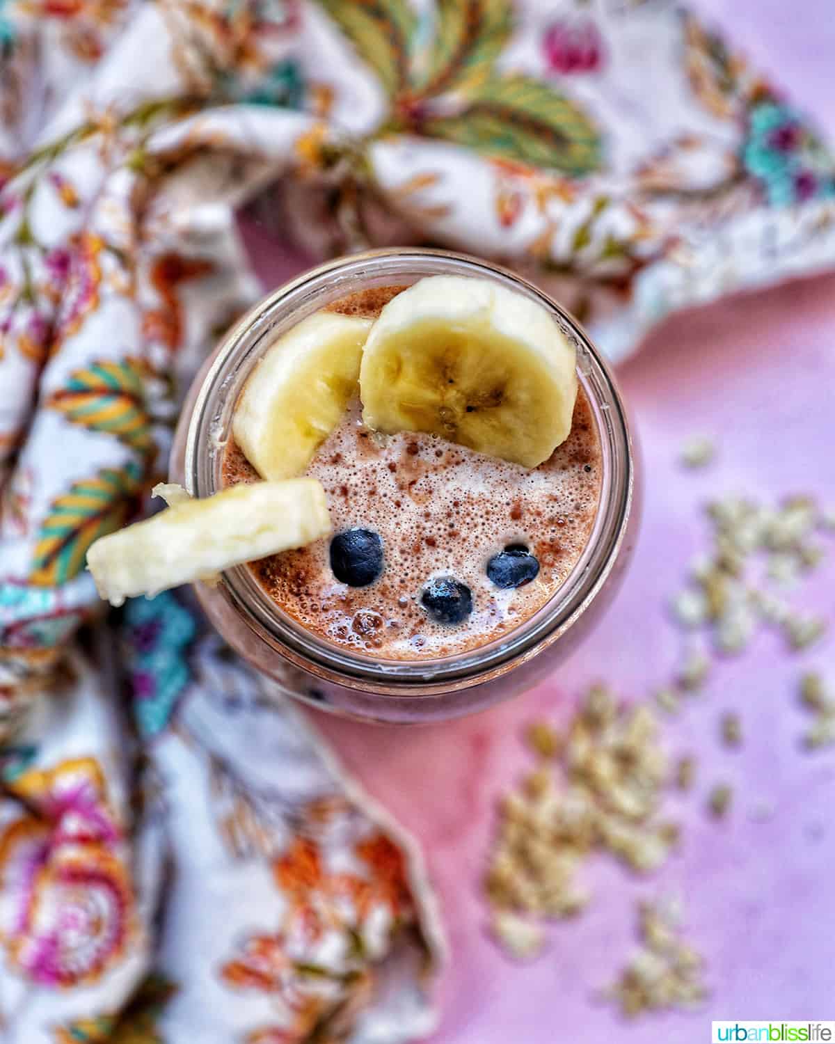 cinnamon roll overnight oats in a mason jar topped with sliced bananas and blueberries.