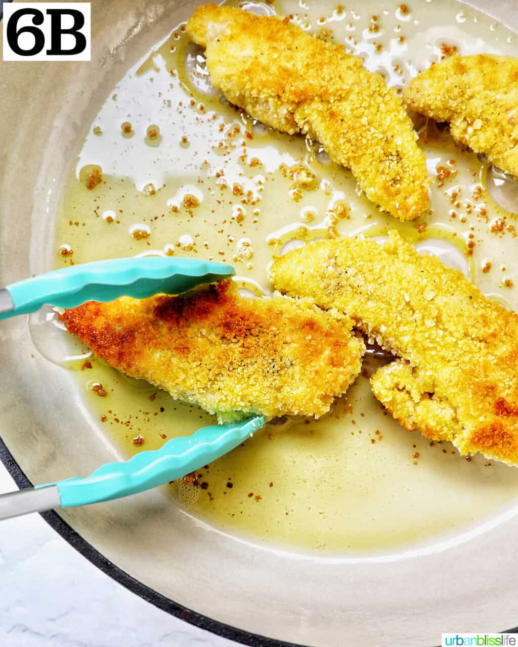 tongs turning over breaded chicken tenders in a skillet.