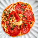 air fryer mini pepperoni pizza on a scalloped plate.