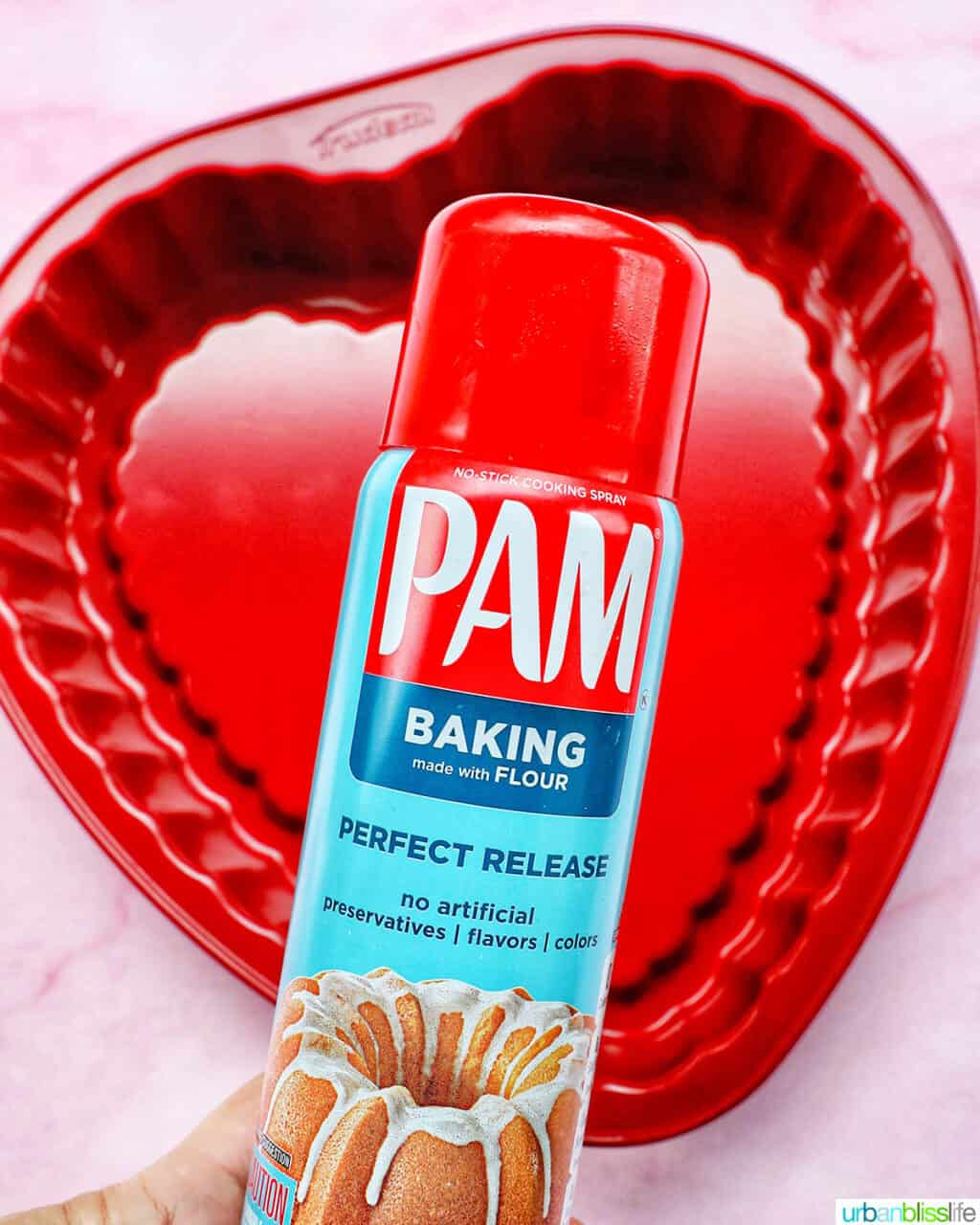 Pam baking spray over a red heart-shaped baking pan.