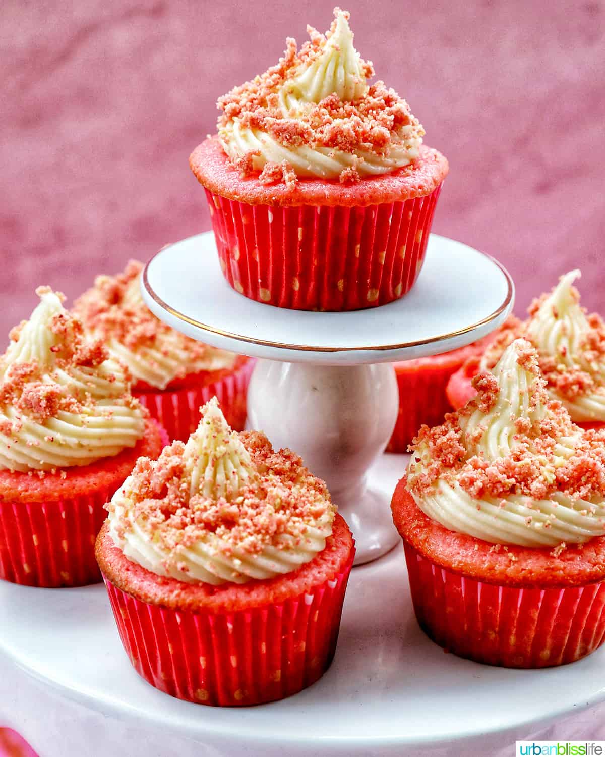 several strawberry crunch cupcakes on stacked cupcake pedestals.