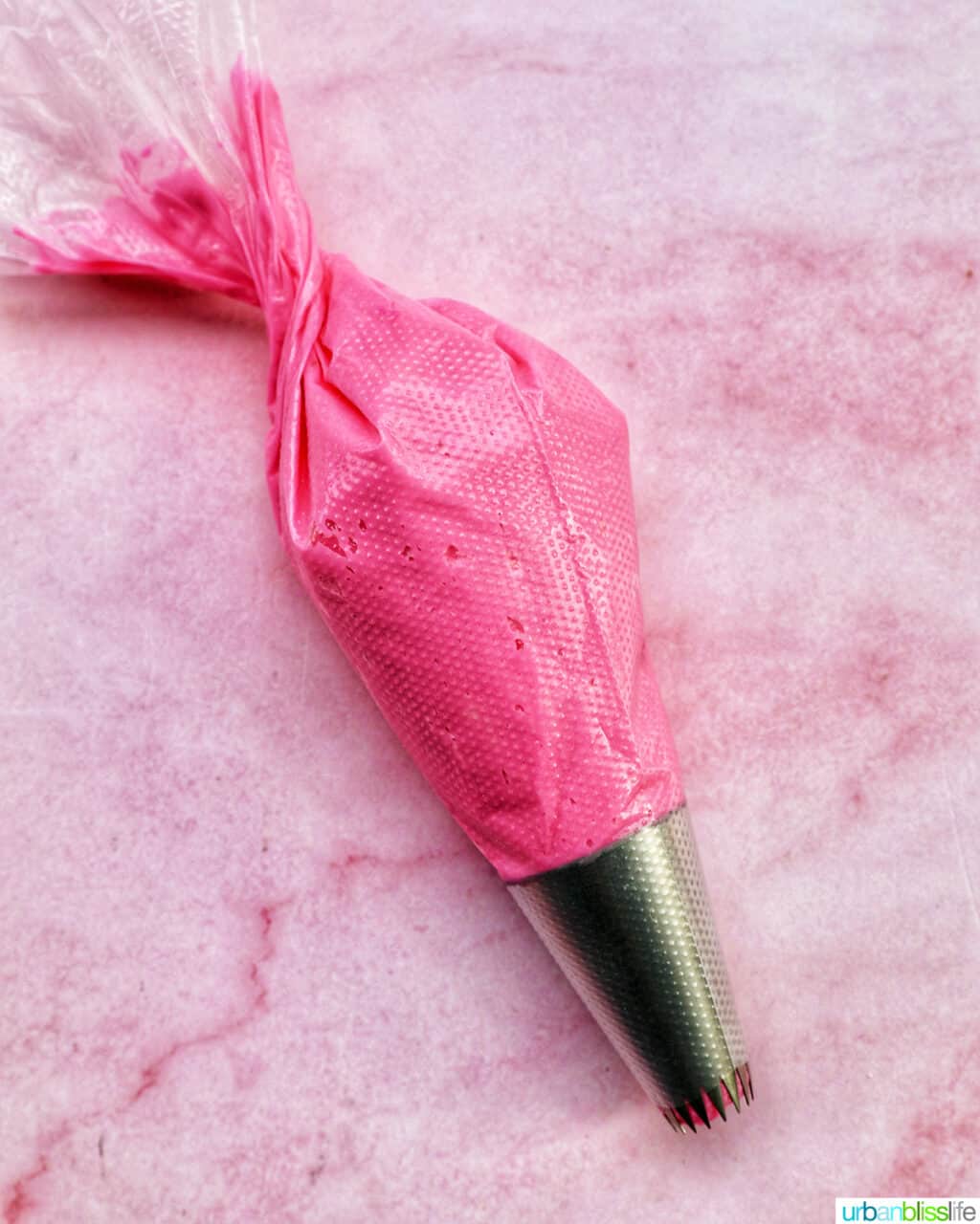 pastry bag with bright pink frosting inside.